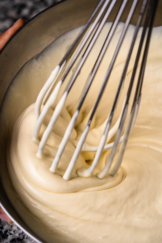 Smooth and creamy cake batter being whisked in a bowl, perfect for baking scenes.